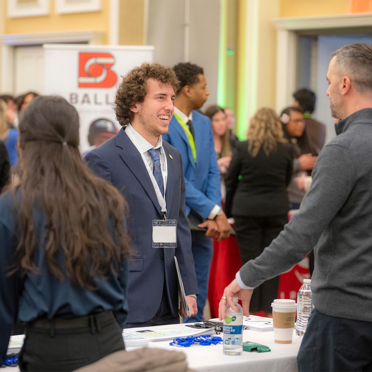 A student shakes talks to an employer during a career fair.
