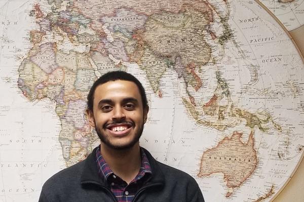 Robert Green in front of map of the world