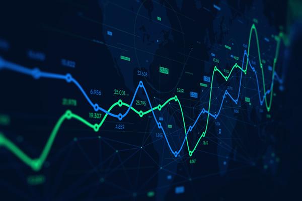 A monitor displaying digital analytics data visualization and financial schedule