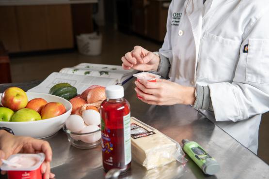 Closeup of a student's hands working with food ingredients in a kitchen