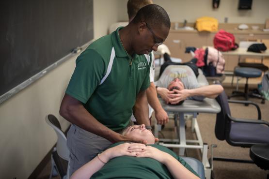 Physical therapy student manipulates a patient's neck