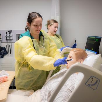Nursing student examines a dummy in a hospital environment