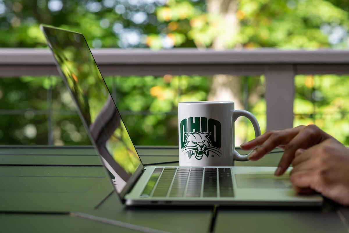 OHIO coffee mug next to a laptop computer
