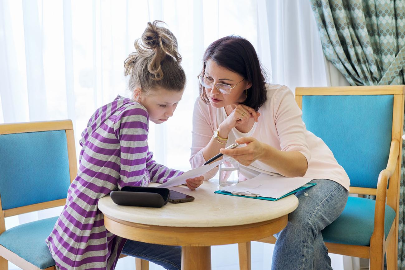 Adult counselor talking to a young teenage girl.