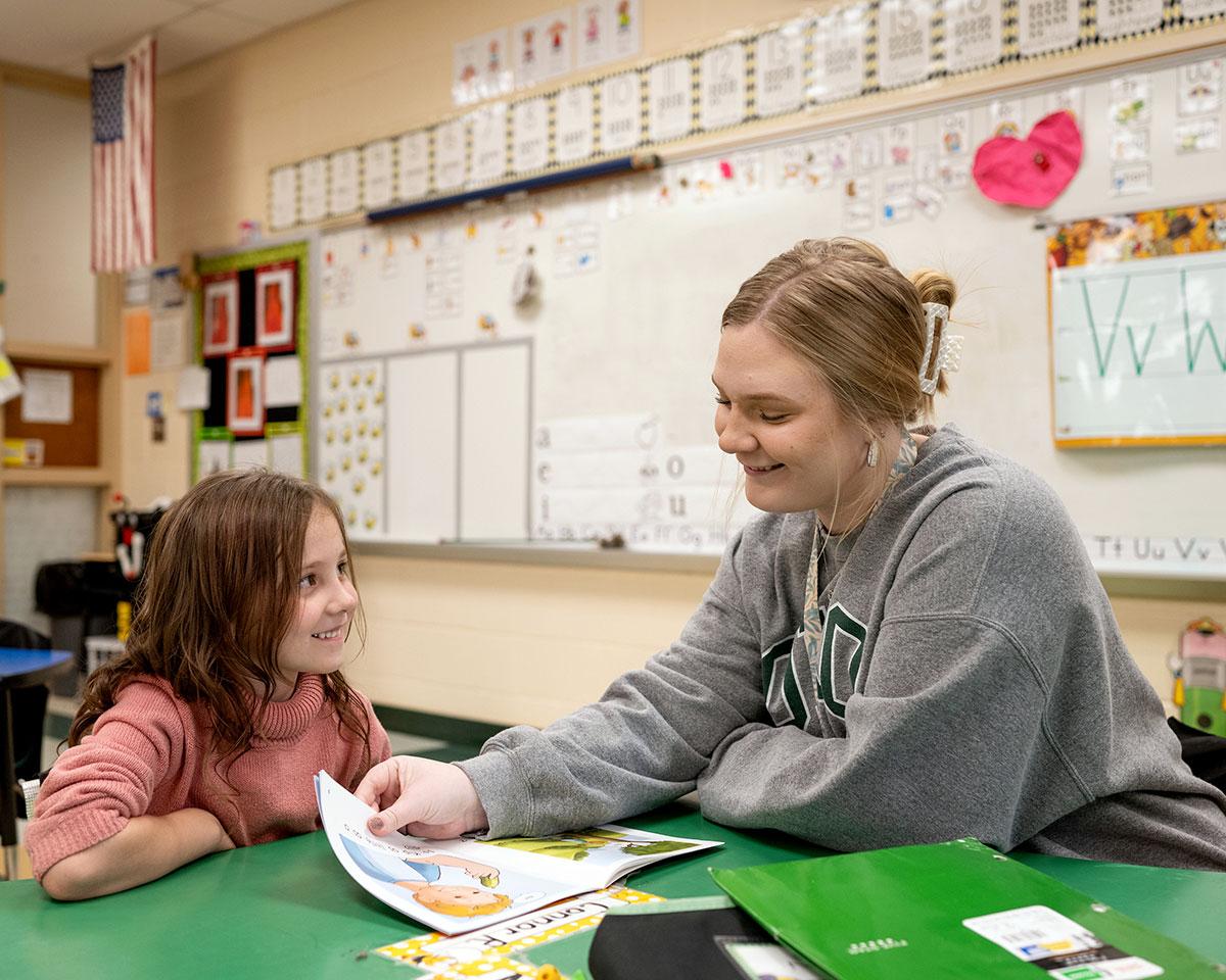 Teacher education student works one-on-one with an elementary school student in a classroom