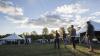 People walking around a festival with tents.