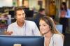 Two people working at a computer.