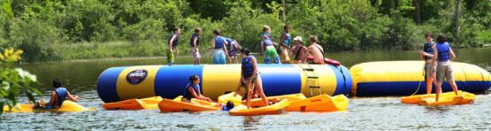 Kids playing on inflatables in the lake.