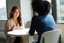Two people sitting across from each other talking