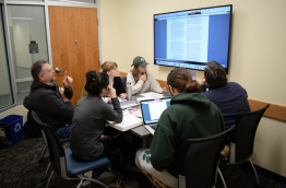Students and Faculty meeting in a Group Project Room