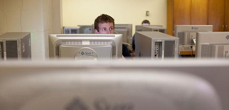 Man sitting in front of a Sun Microsystems computer