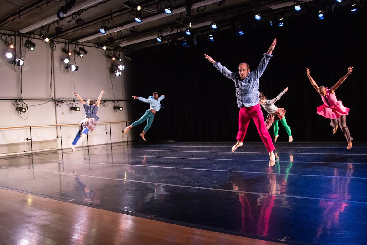 People jumping in the air on stage during dance practice or performance
