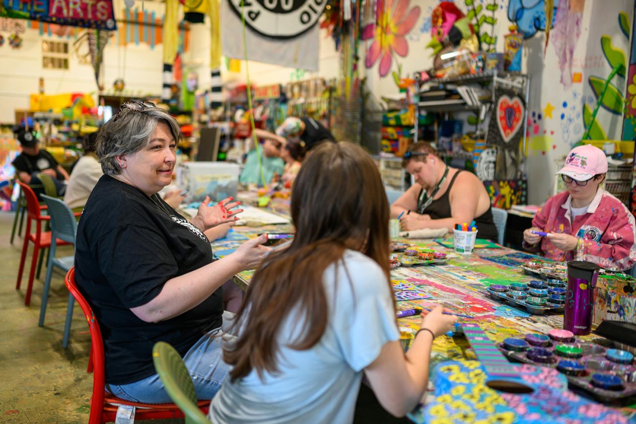 volunteers and artists working on painting art pieces at Passion Works Studio