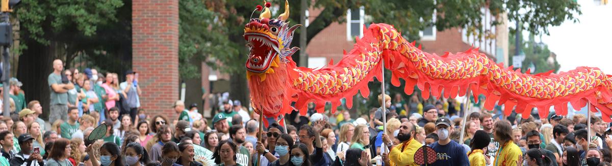A large fabric dragon is held up on poles at an Ohio University event