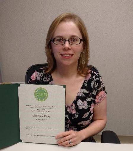 Catherine Perry holding award