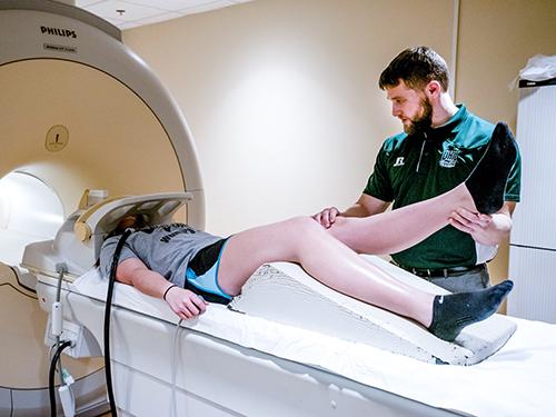Dustin Grooms helps a patient through an MRI machine