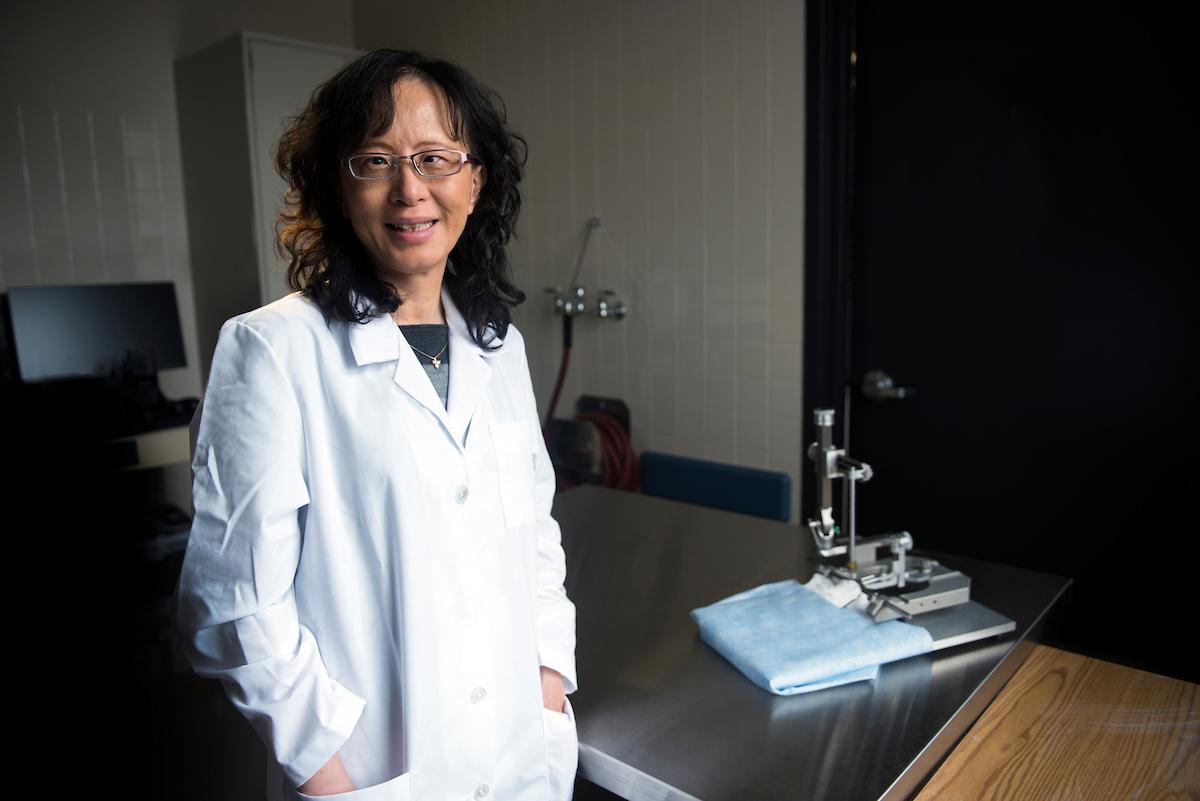 Chunmin Lo in lab wearing a lab coat
