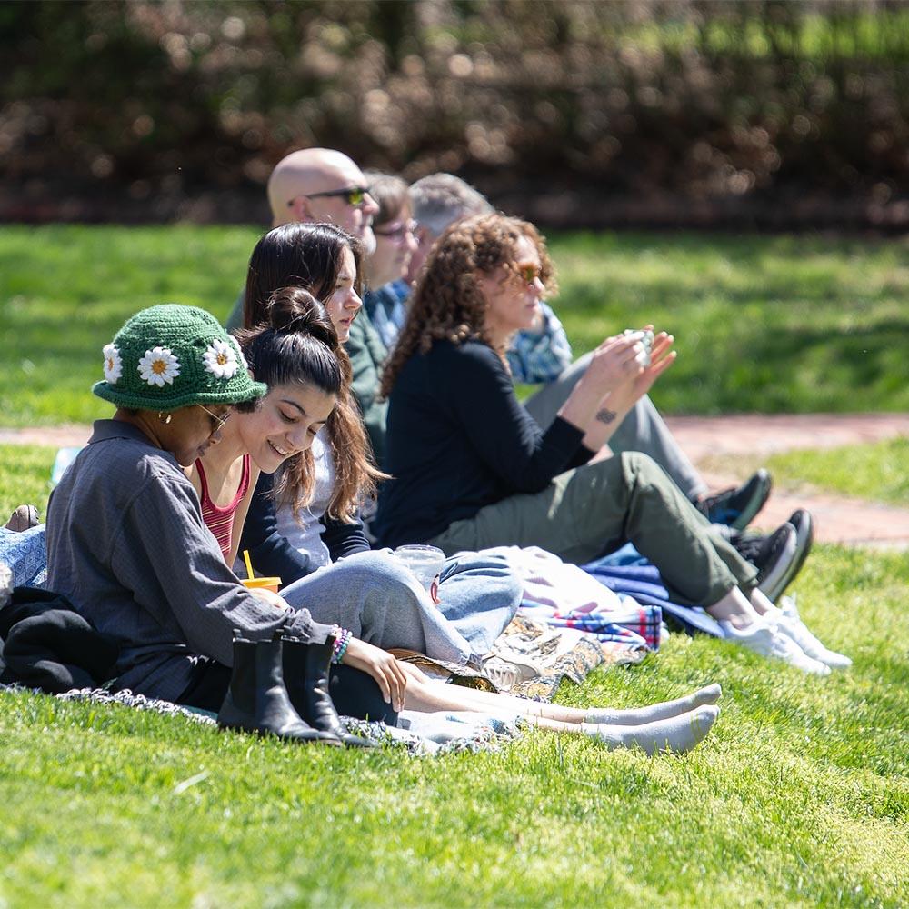Students sitting together outside of the Scripps Amphitheatre.