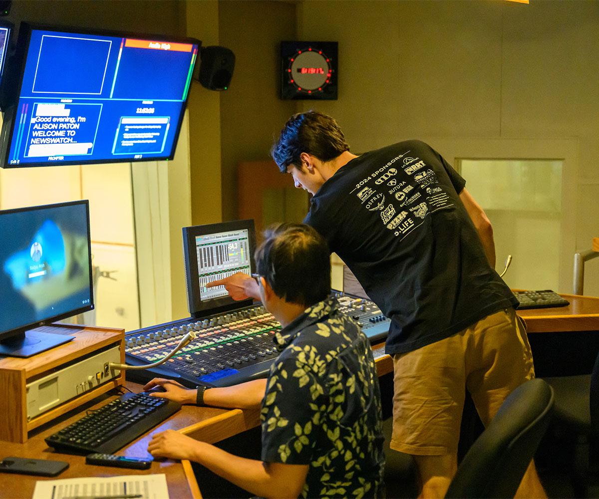 A student and instructor work in a media lab.