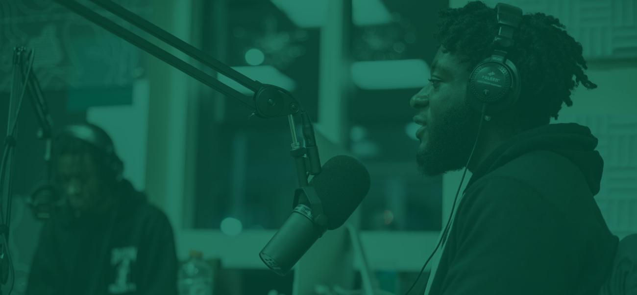 Communication student talks into a microphone at Ohio University's podcast studio