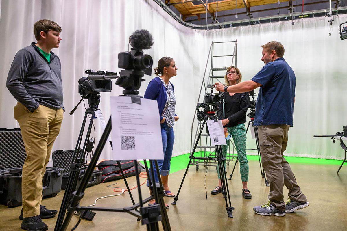 Students and faculty work with film equipment on set