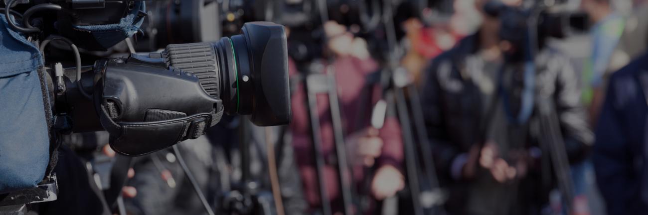 A photo of cameras lined up at a news conference