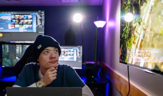 Student looks at a screen while editing video footage in the visualization lab