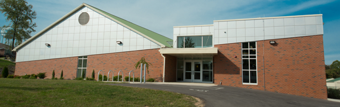 A brick building with an ascending parallel line of white tile.