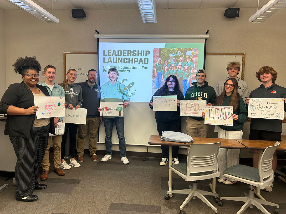 Students in the Leadership Launchpad hold up posters about leadership they