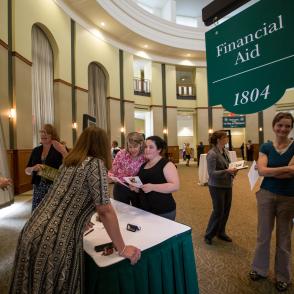 Group of people in conversation about financial aid at a table. 