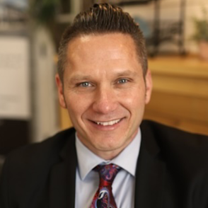 Headshot of man in suit smiling