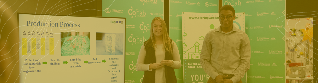 Two students stand at their poster session for entrepreneurship week