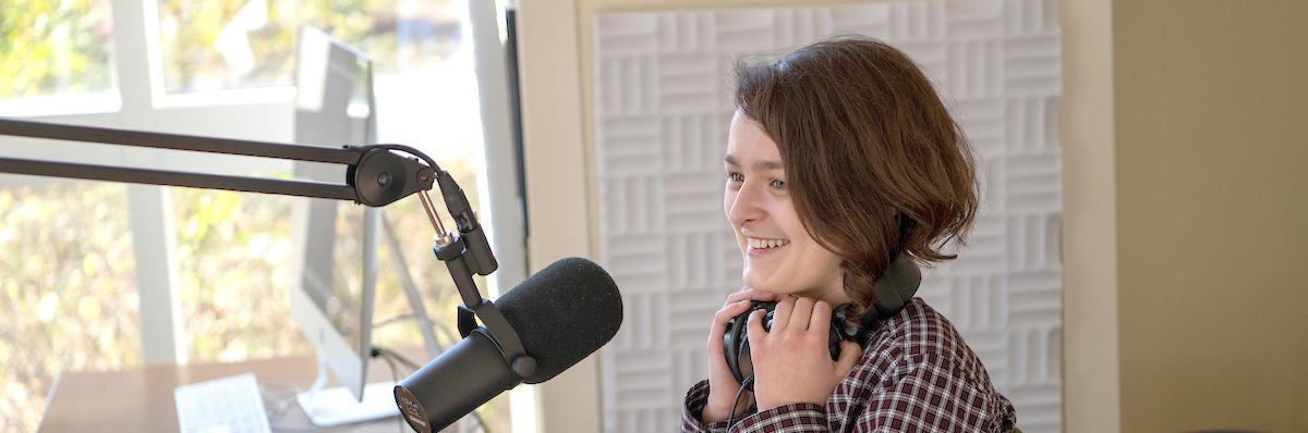 Student sits behind a microphone 