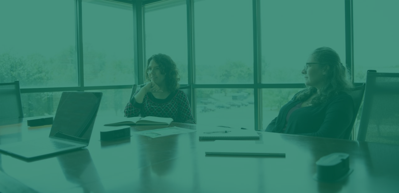Two faculty and staff members attend a meeting.