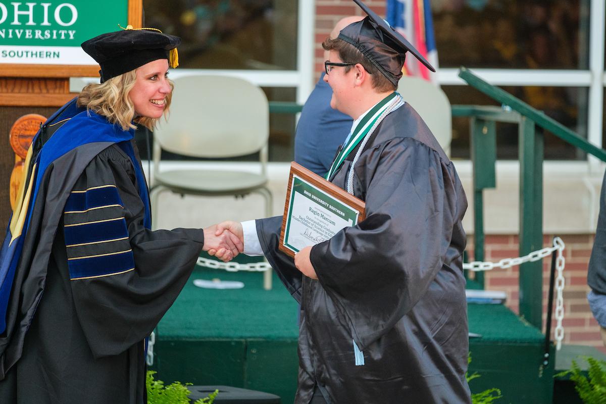Dean Marinski shaking hands with graduate