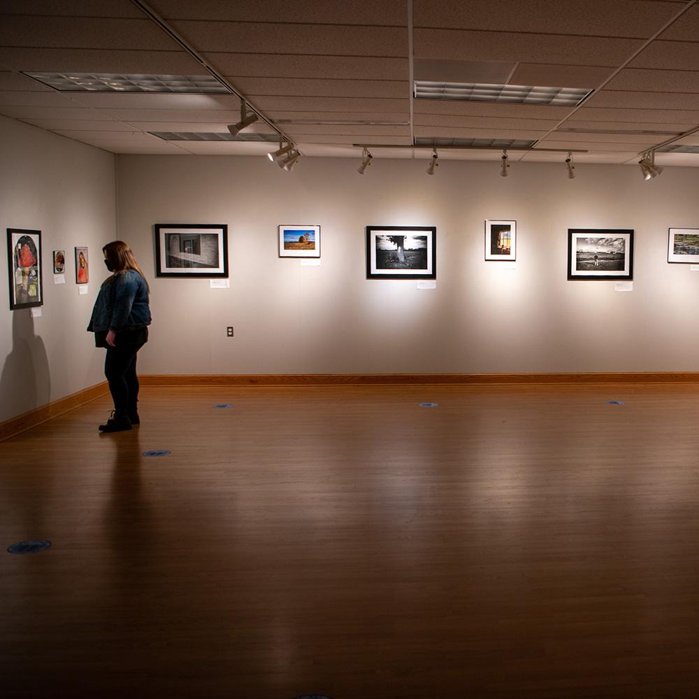 A person looks at a piece of art in the gallery.