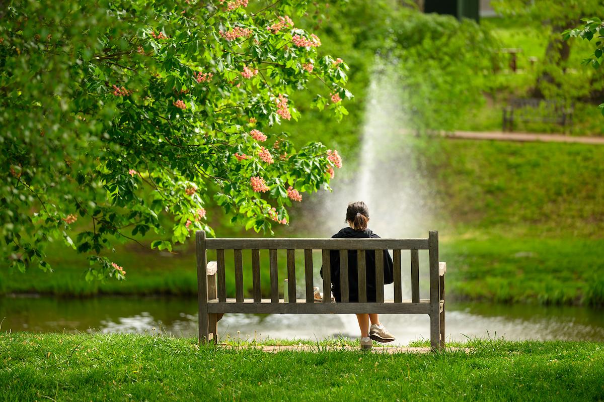 Woman sitting on a bench at Emeriti Park on Ohio University's Athens Campus
