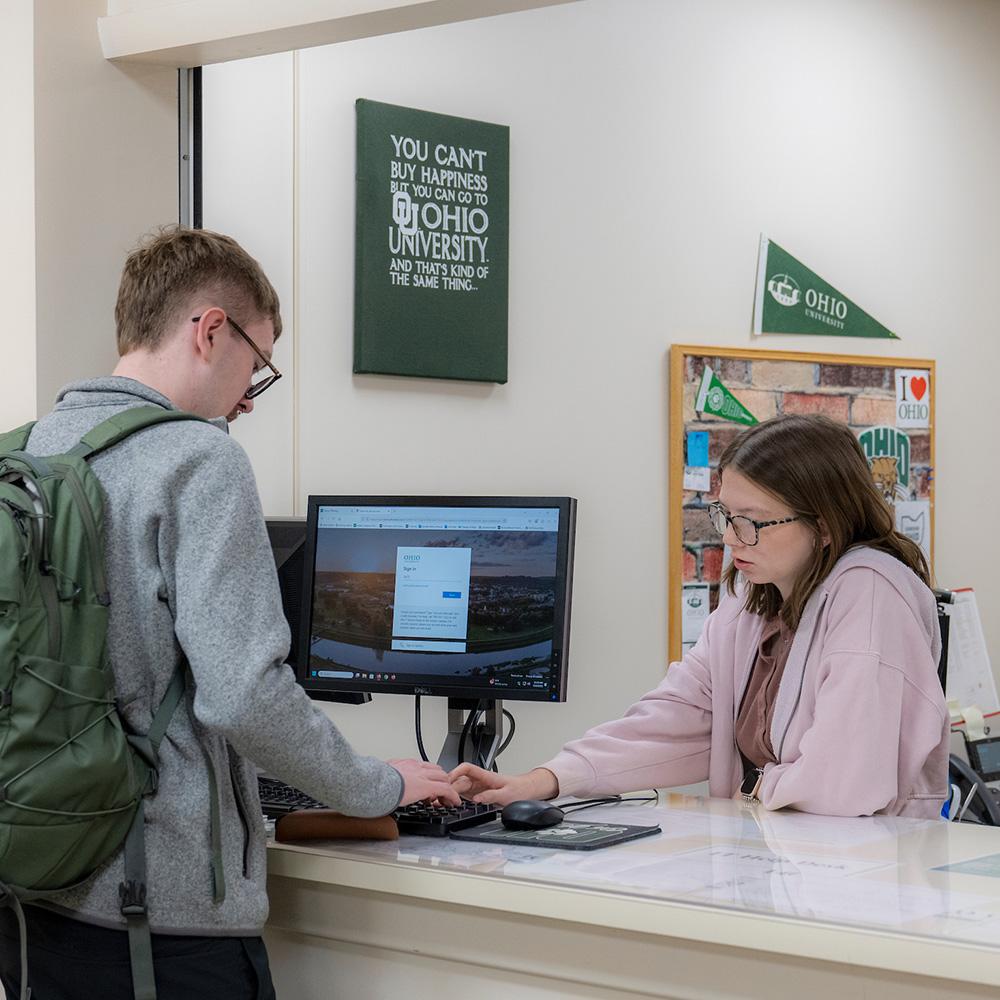 A student worker helps a student with their schedule.