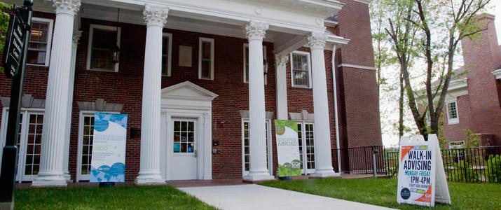 A brick building with white columns known as the Walter Student Success Center.