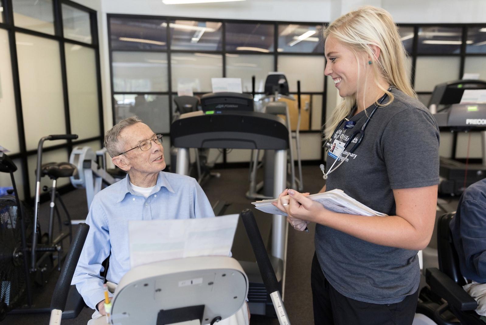 HeartWorks staff with client on cardio machine