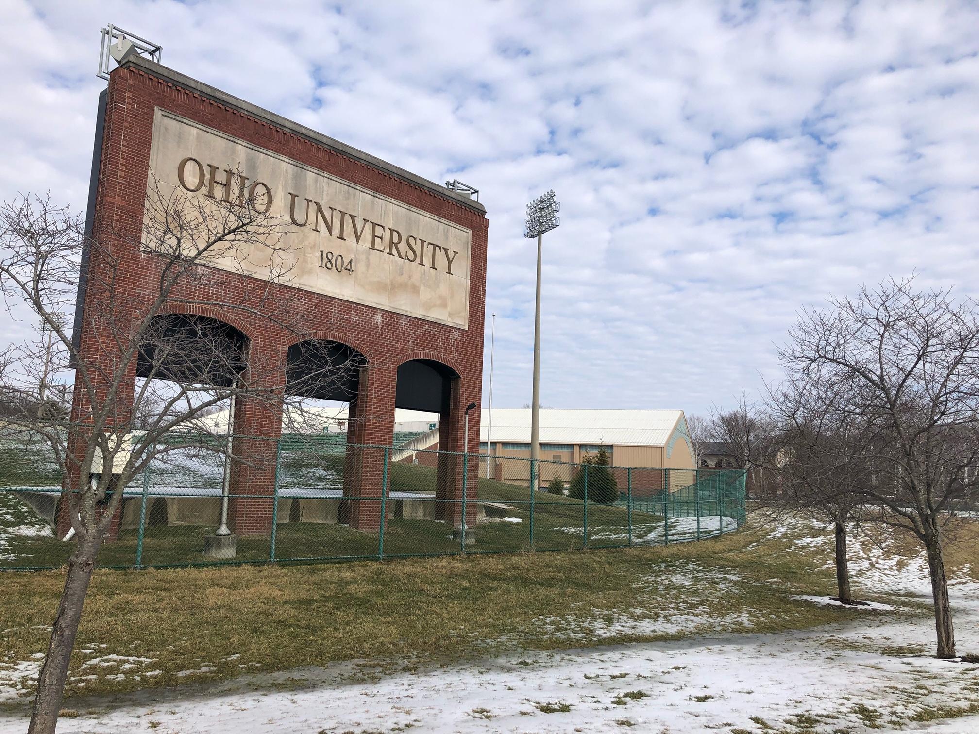 Bare cherry trees in front of Penden Stadium with light snow on the ground