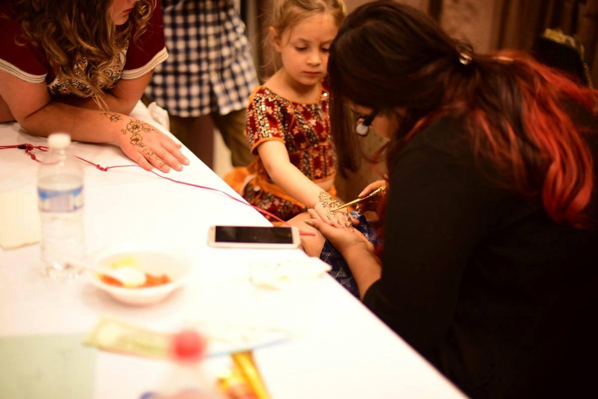 Young girl getting henna tattoo done at the Indo-American Friendship Day Celebration