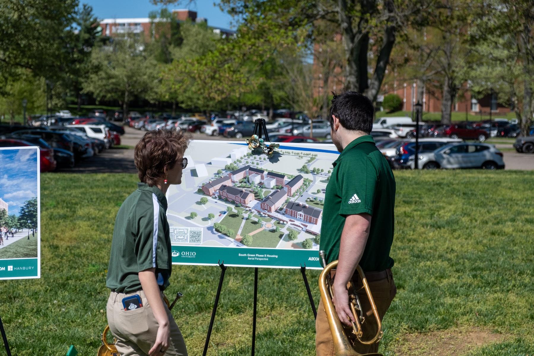 students looking at the renderings of the new residence halls