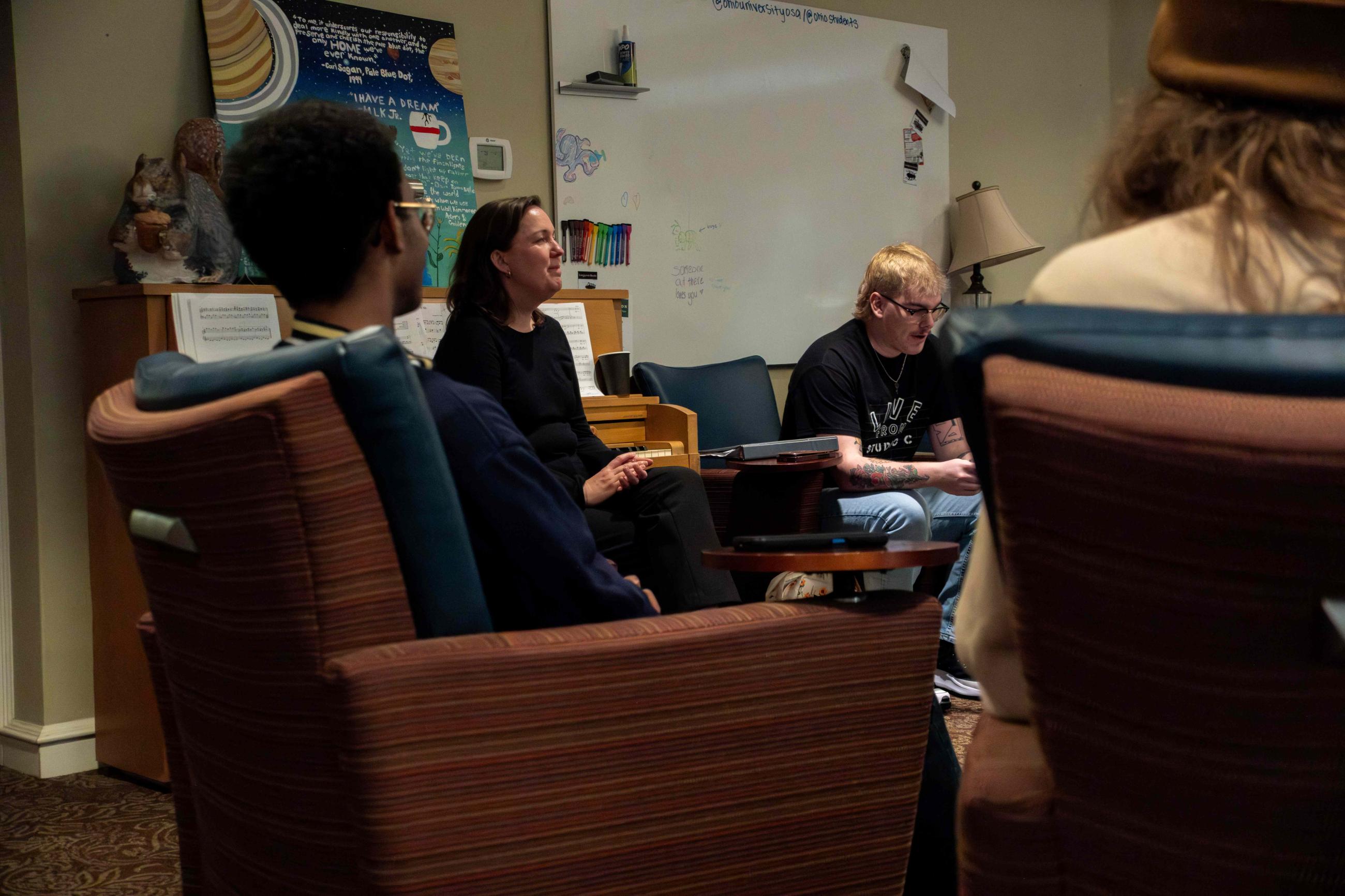 Sarah Green seated with students at an Open Mic event