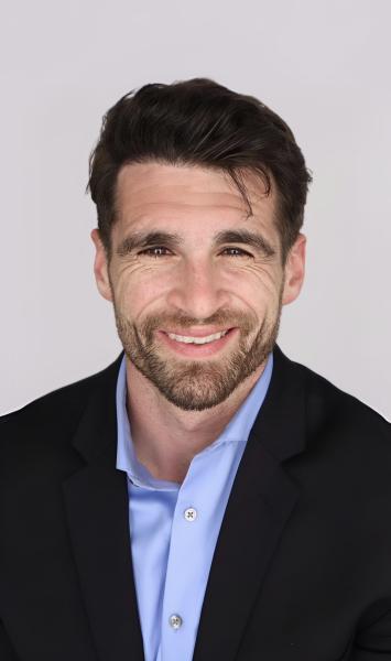 Tony Gregory smiles at the camera for a professional headshot