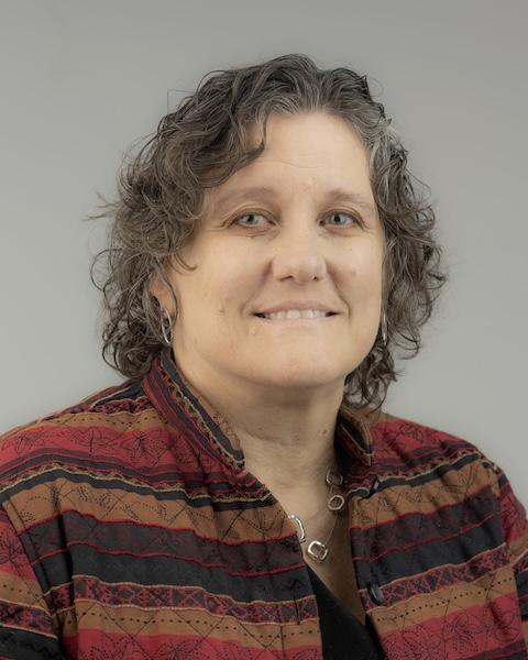 Loralyn headshot. She is wearing a multicolored coat