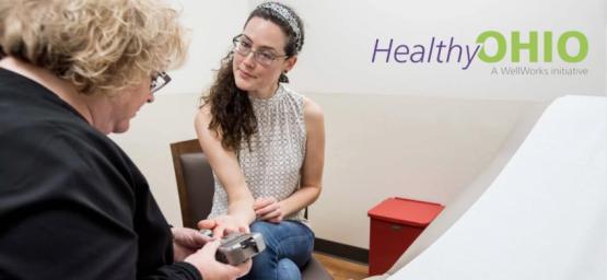 Person getting a health screening from a nurse.