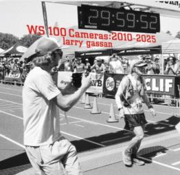 Black and white image of photographer taking photo of person completing a race.
