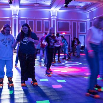 students and family roller skating inside Baker Ballroom