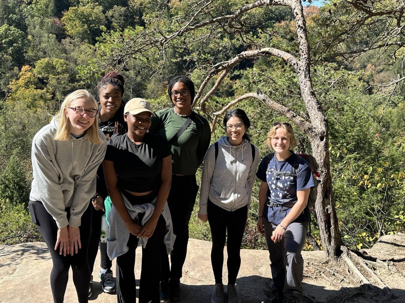 Students smile together while hiking outside